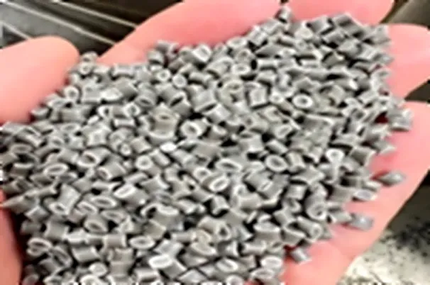 Hand holding mixed-color recycled homopolymer polypropylene pellets